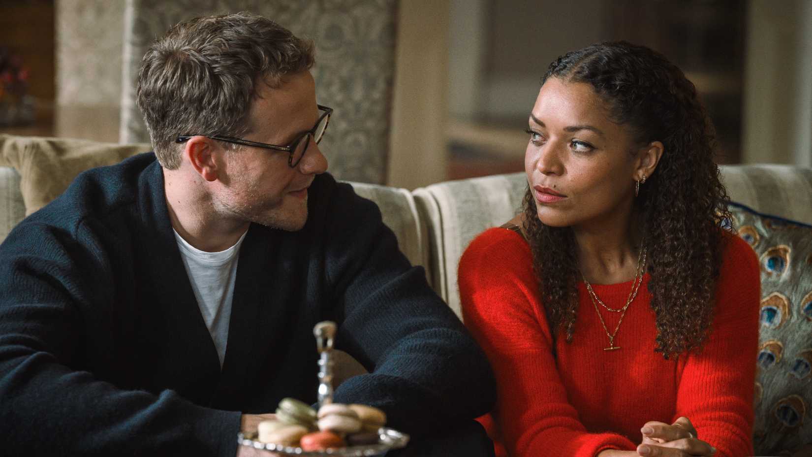 Josh Dylan as Tommy and Antonia Thomas as Tuppence looking at each other in BritBox's Tommy & Tuppence