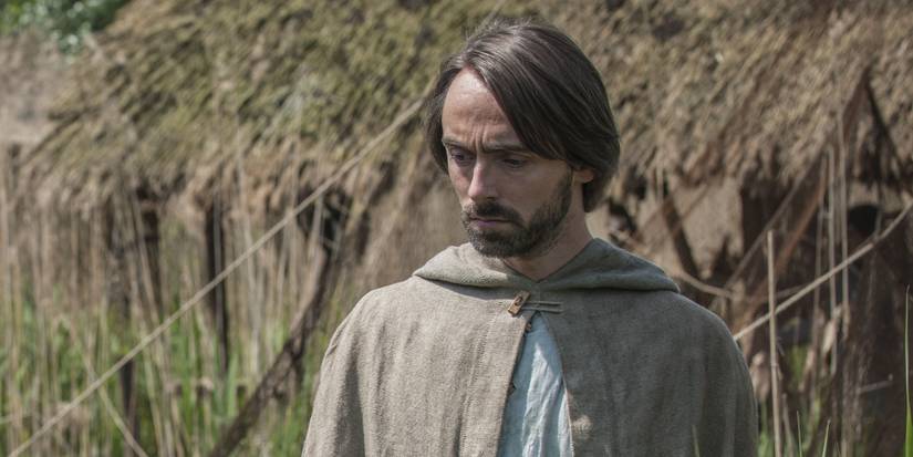 King Alfred looks down while wearing peasant clothing in The Last Kingdom season 1, episode 7