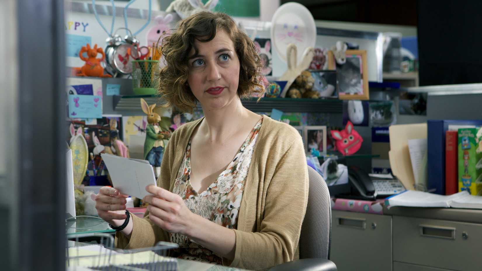 Kristen Schaal at her desk in Welcome to the Jungle