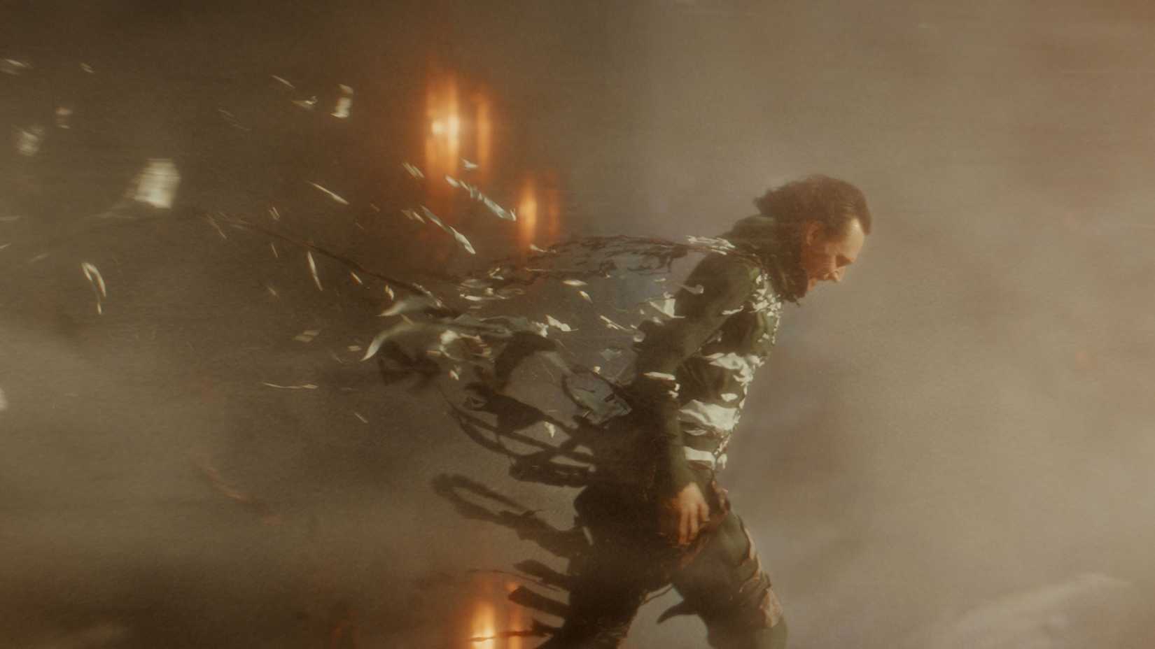 Loki (Tom Hiddleston) walking through a time storm in Loki.