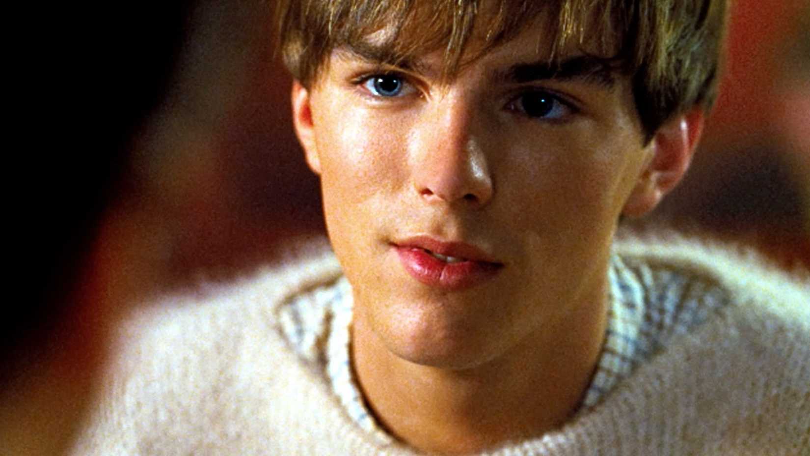 Kenny (Nicholas Hoult) smiling at someone in A Single Man.