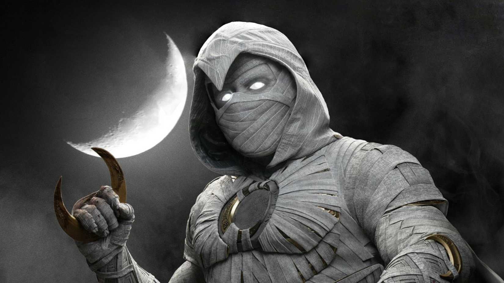 Moon Knight holds a moon shaped blade while in front of a crescent moon in the TV show Moon Knight
