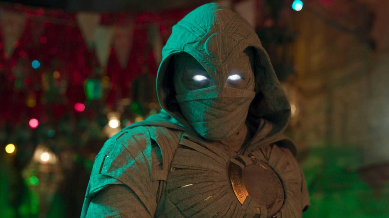 Moon Knight's eyes glow while in front of a green and red background in the Moon Knight TV show