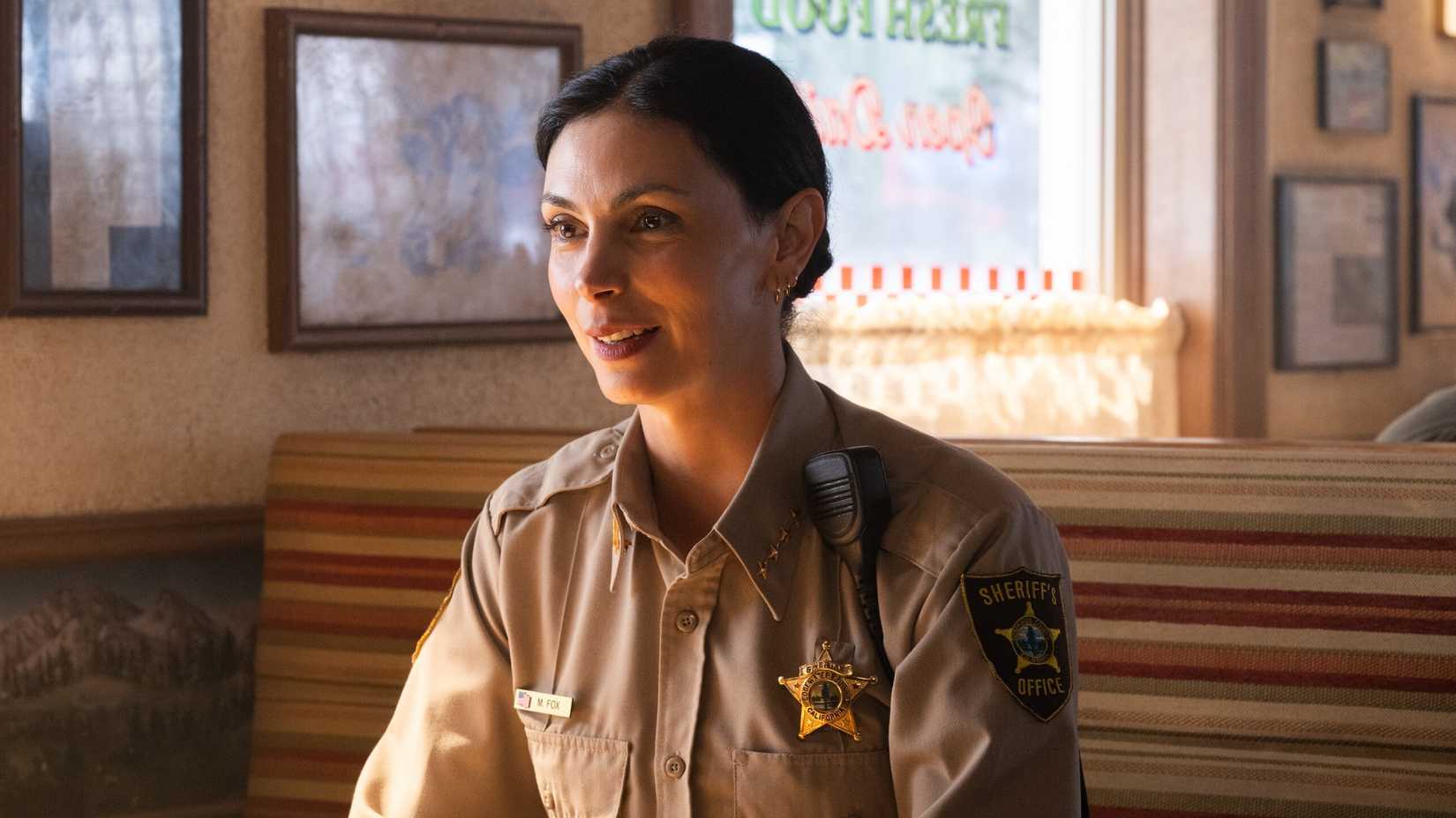 Morena Baccarin as Mickey sitting in a diner in Sheriff Country season 1, episode 1