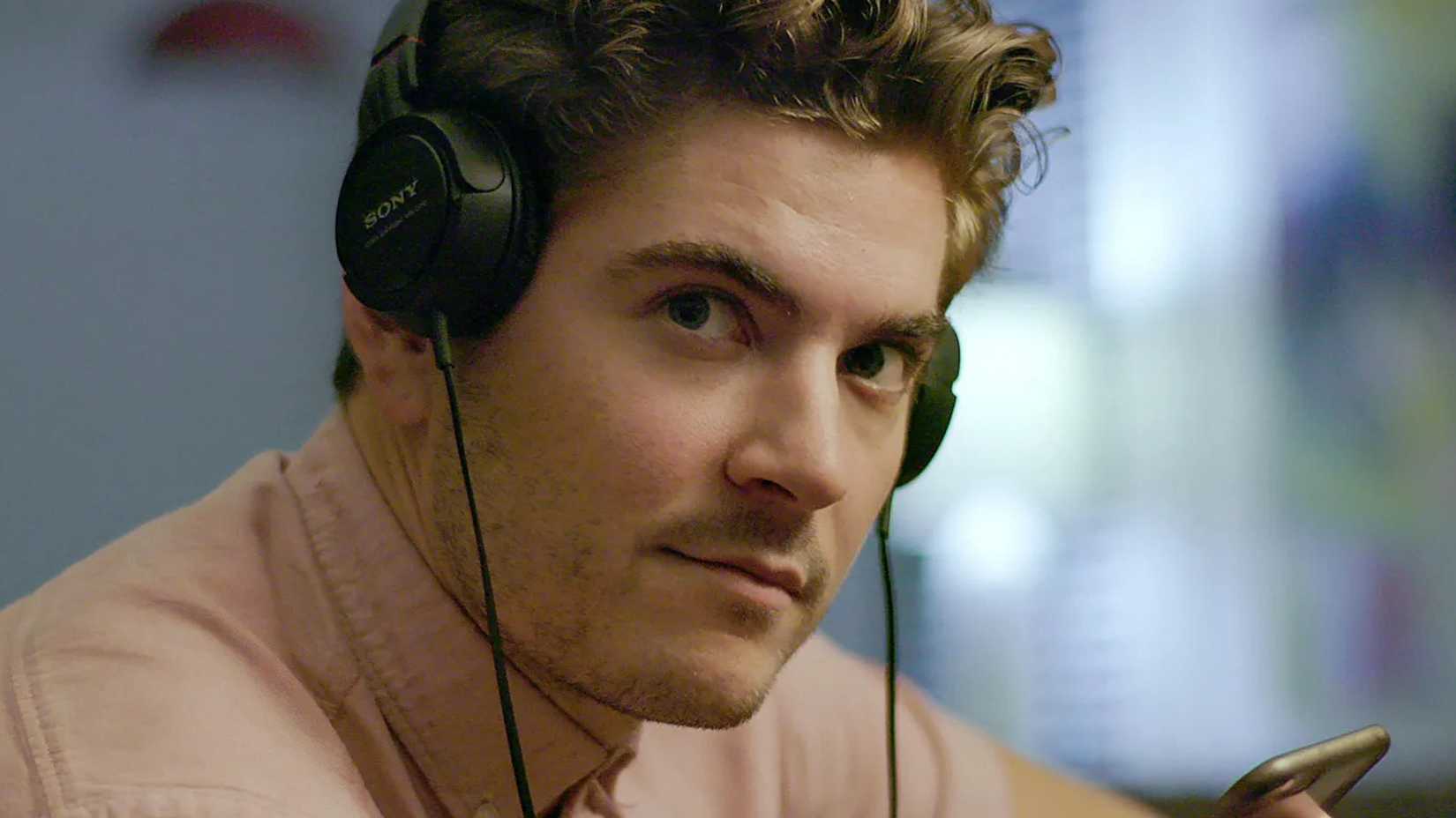A man wearing headphones and looking serious in the HBO docuseries Murder on Middle Beach.