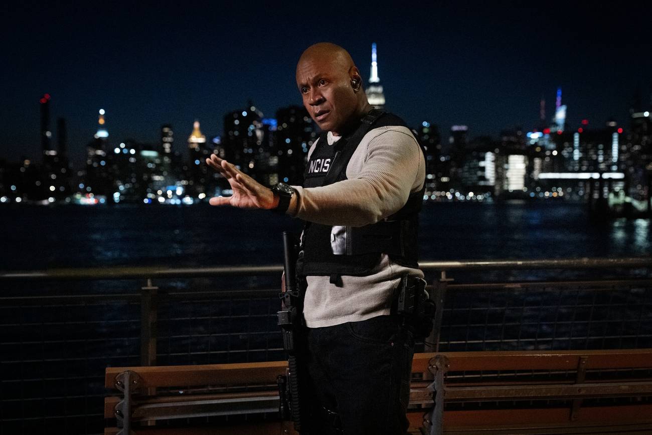LL Cool J's Sam Hanna wearing a bulletproof NCIS vest and holding his hand out at nighttime