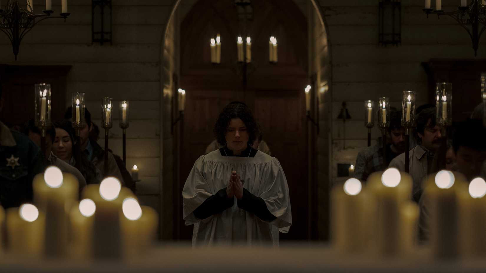 Ooker entering the church surrounded by candles in Midnight Mass
