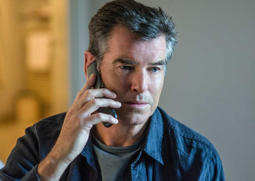 Pierce Brosnan listening to someone on the phone in The November Man