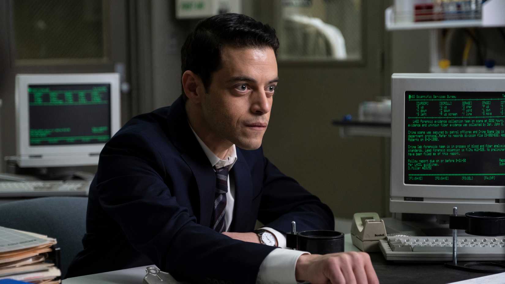 Rami Malek at a desk in The Little Things