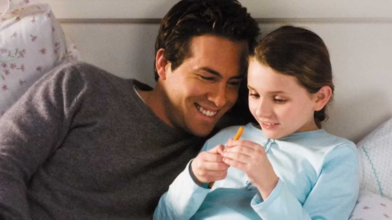 Ryan Reynolds and Abigail Breslin as Will and Maya in bed laughing in Definitely, Maybe