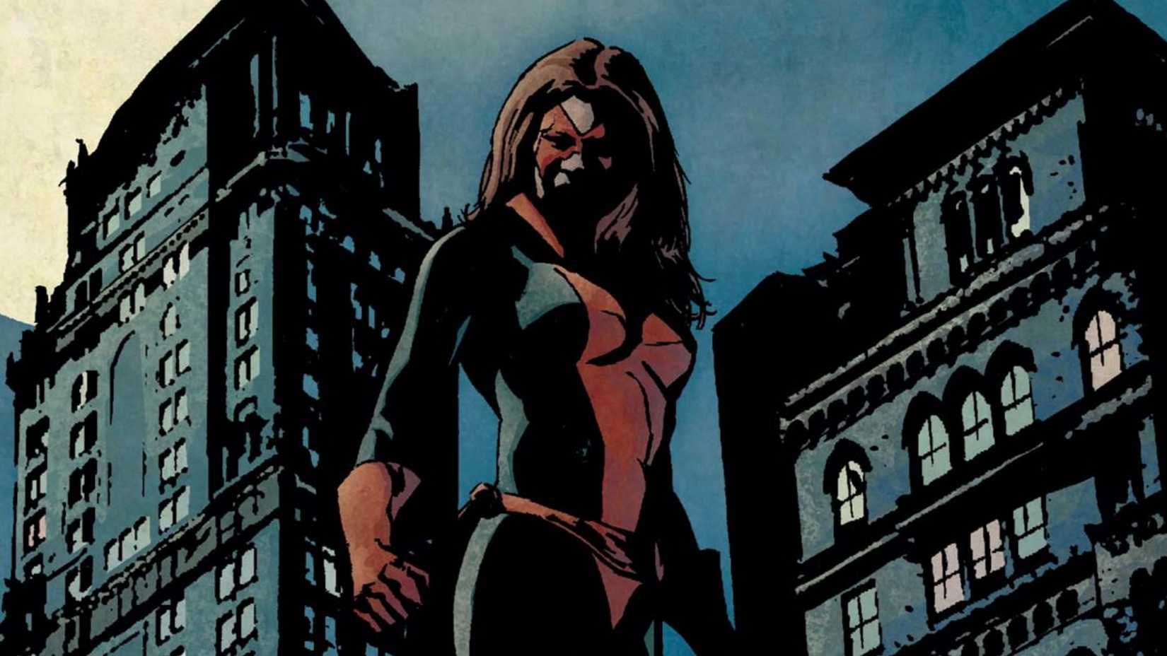 Jessica Jones in her Knightress costume standing on top of a building at night