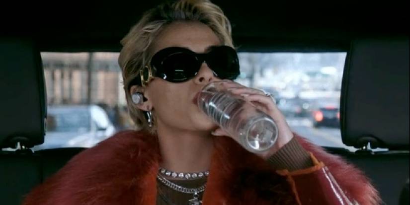 Skye drinking a Voss water bottle in Smile 2