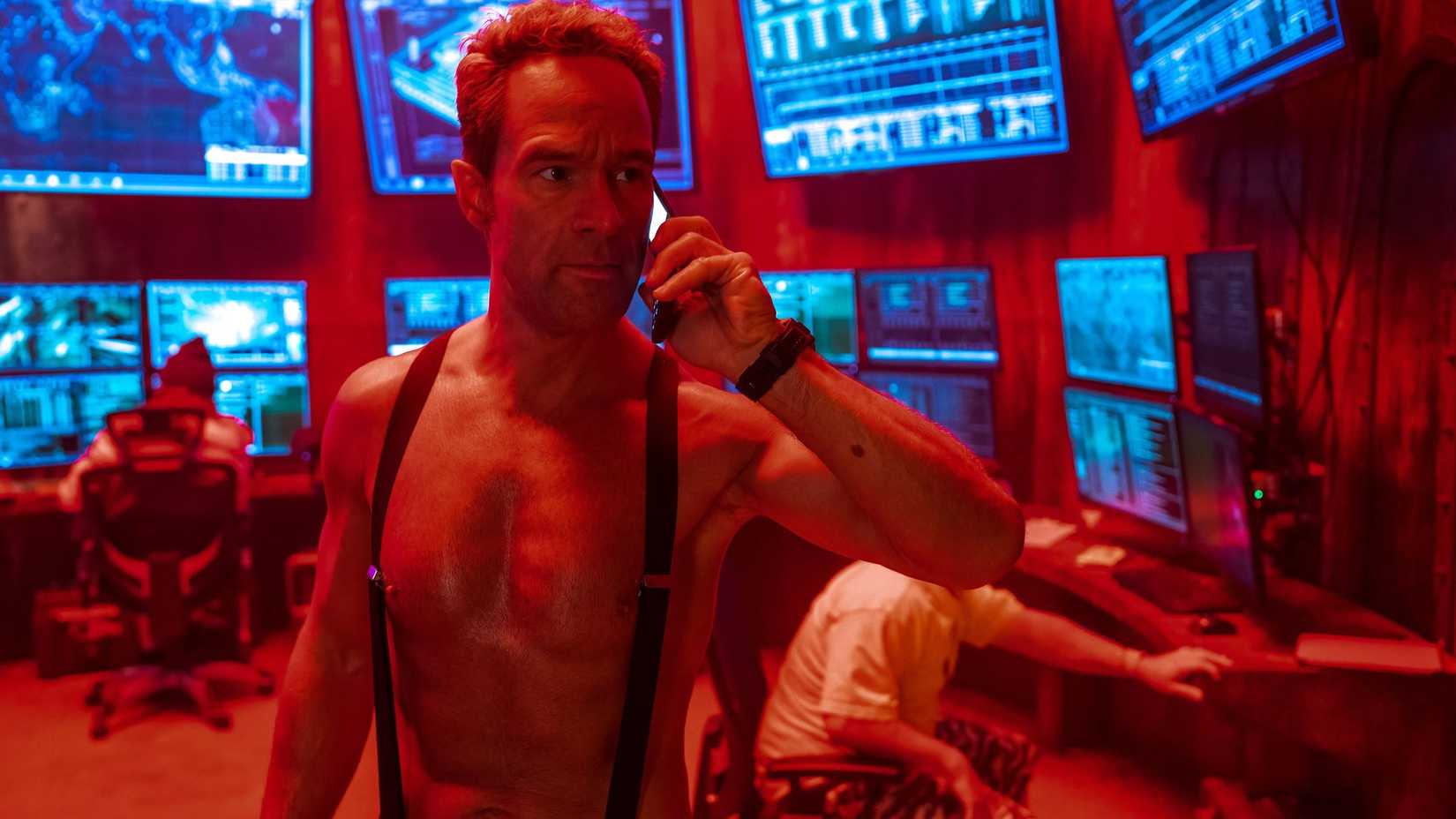 JQ (Chris Diamantopoulos) on the phone in the war room, shirtless in Mrs. Davis.
