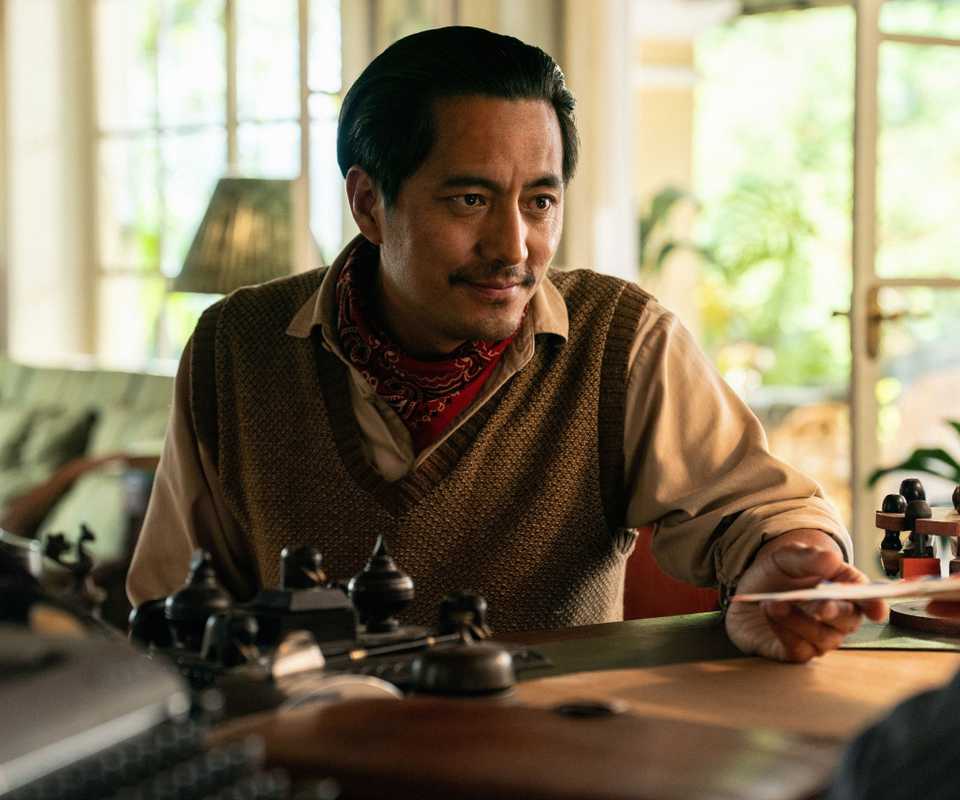 Tenzing Norgay smiling as he's handed an envelope in Tenzing