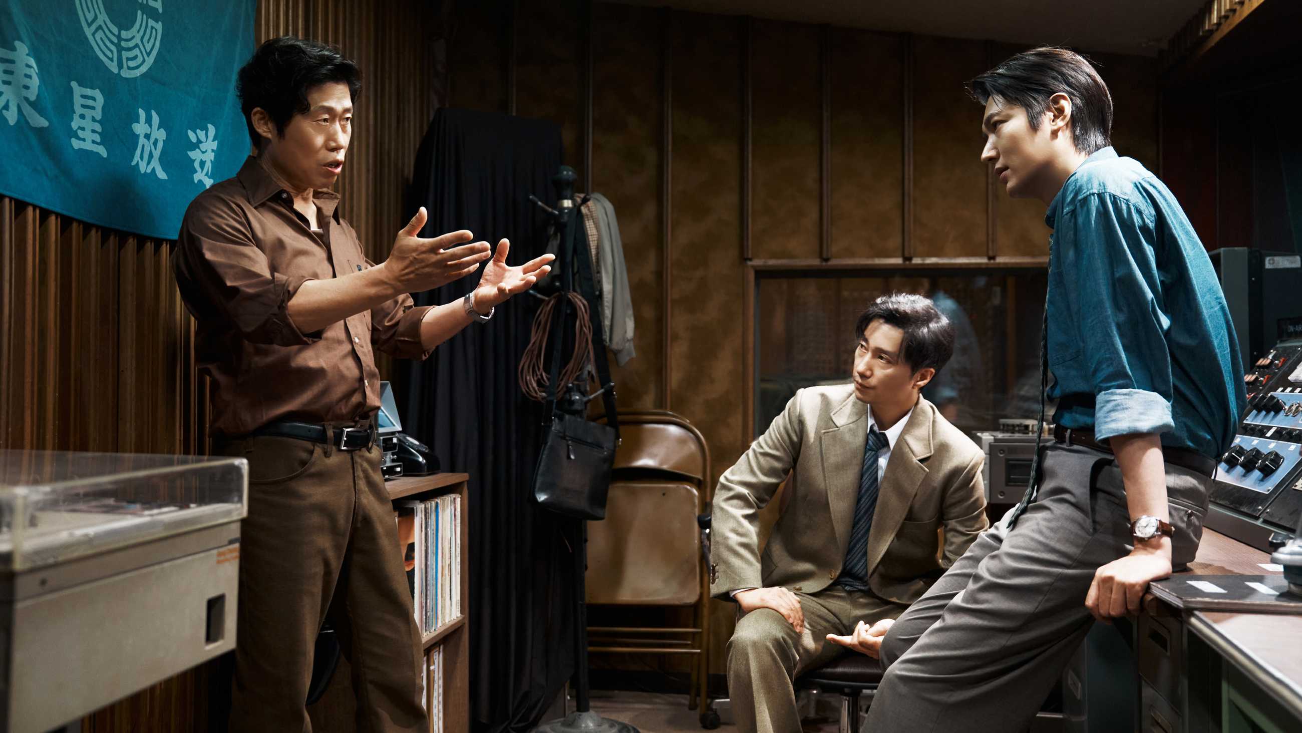 The Assassin(s)' three protagonists talking together in a sound booth