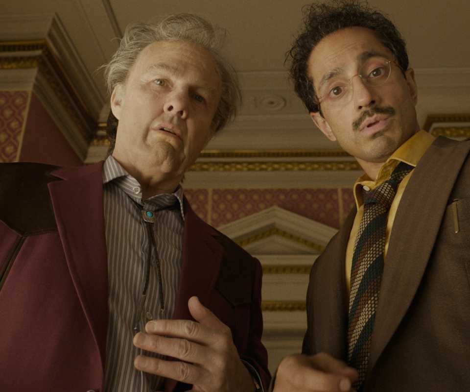 Tom Cruise and Riz Ahmed looking down at something with concerned expressions on their faces in Digger