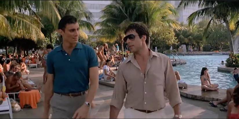 Tony talking to Manny by a pool in Scarface