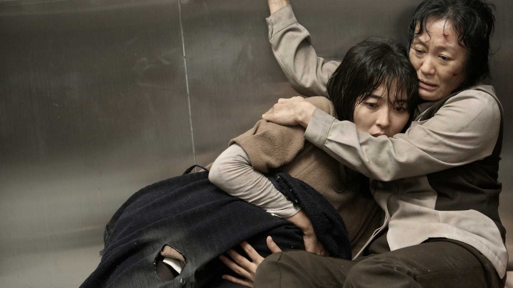 Two people huddle together in a broken elevator in The Tower (2012)