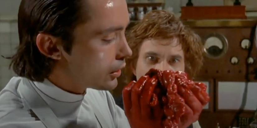 Udo Kier as Frankenstein holding guts in Flesh for Frankenstein