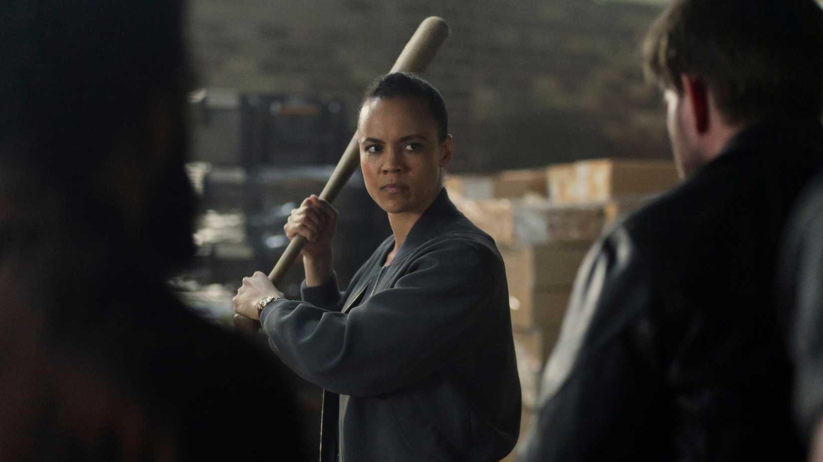 Neagley wielding a baseball bat and facing two characters