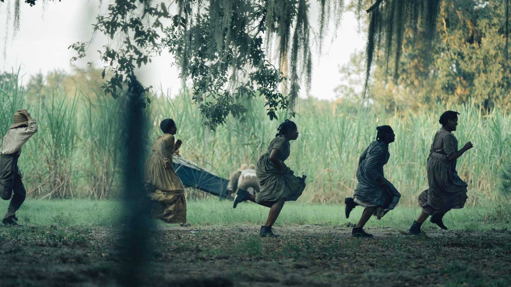 Several black women in colonial dress are running from something on a plantation.