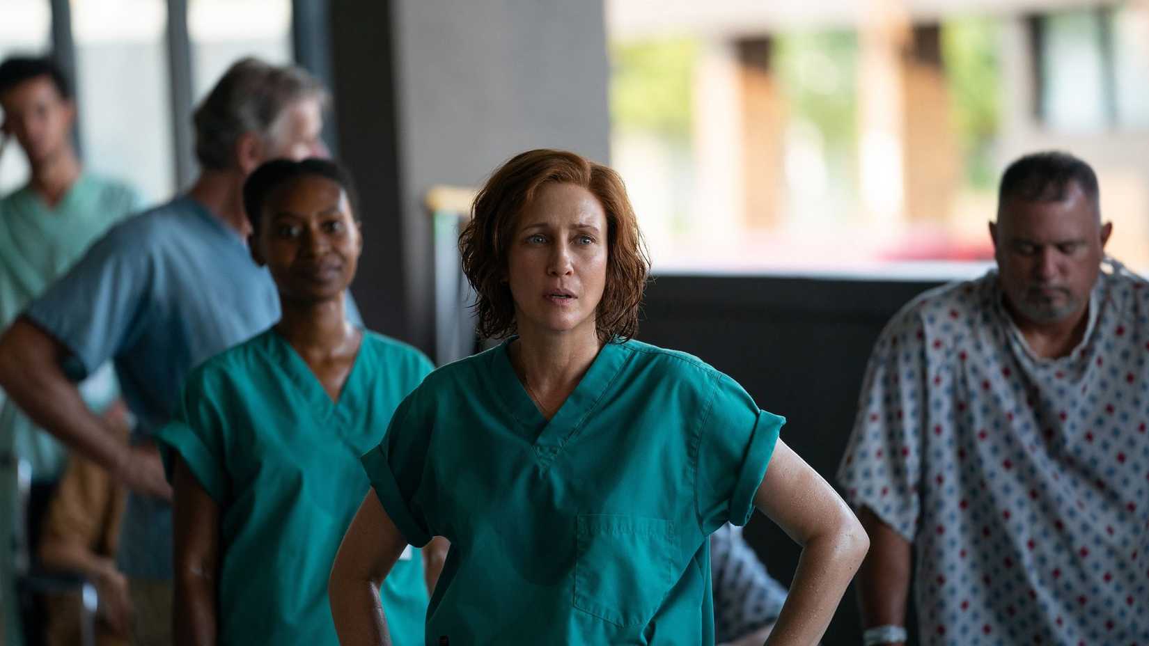 Nurses and patients stand in a hospital hallway