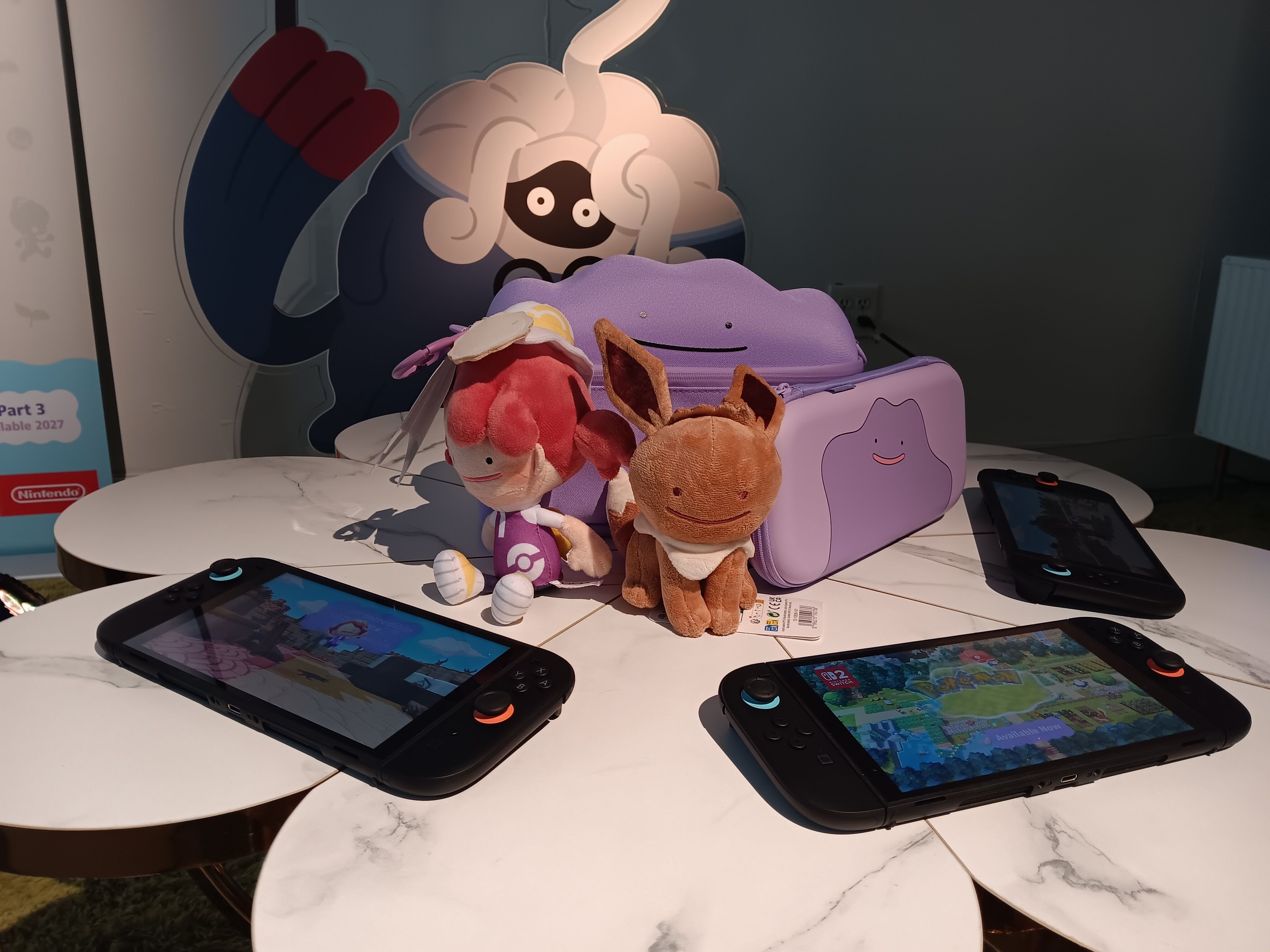 Pokemon Pokopia plushies and merch next to Nintendo Switch 2 consoles