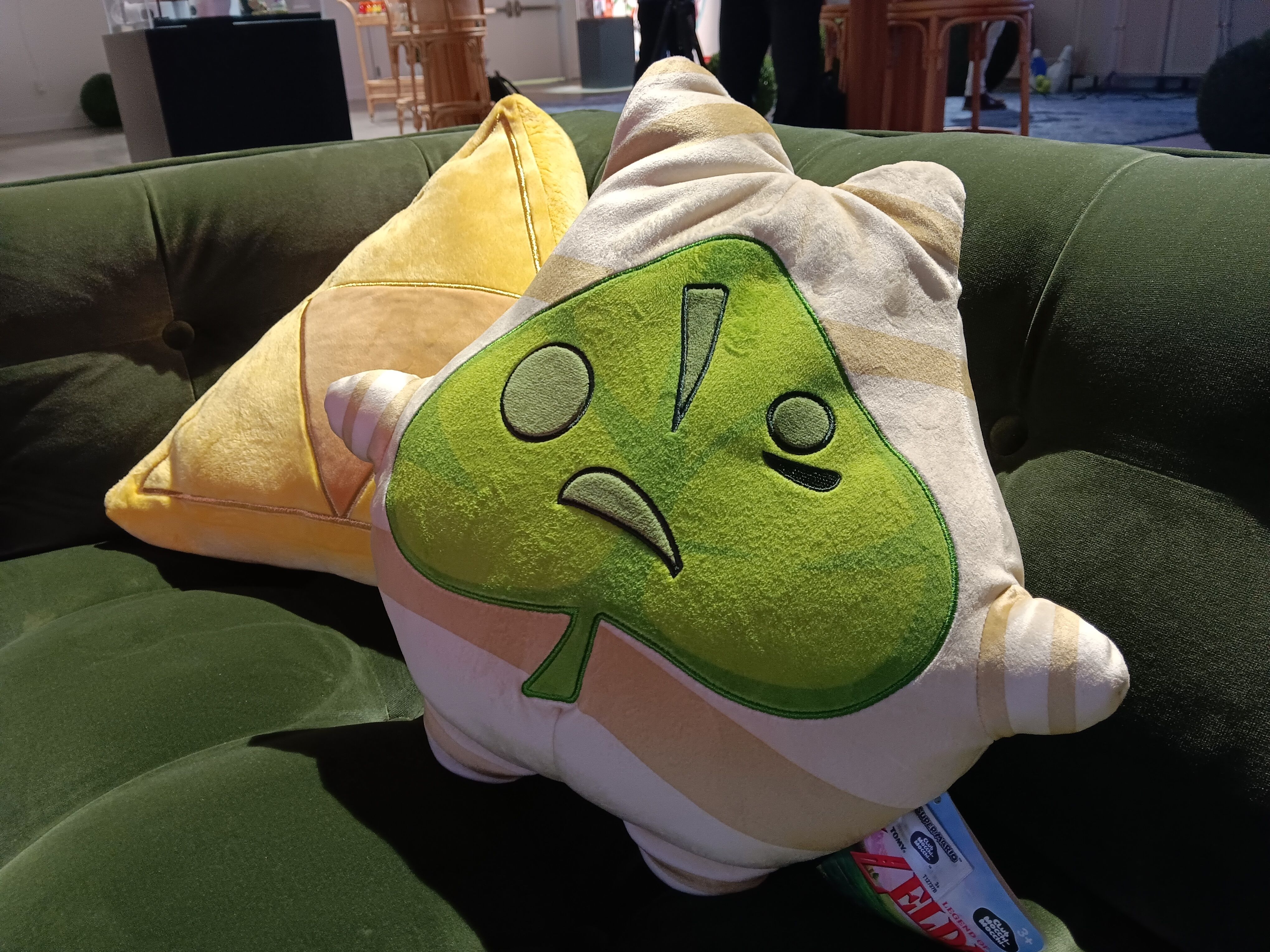 Throw pillow korok and triforce on a green couch at the Nintendo 2026 holiday showcase