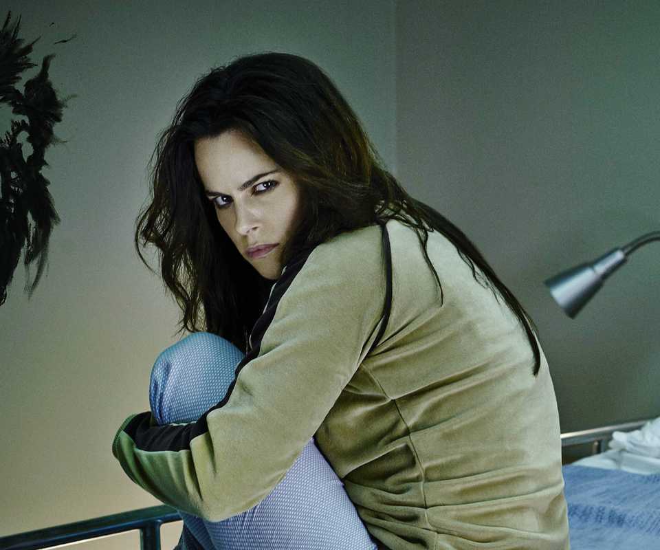 Emily Hampshire’s Jennifer sitting on a bed in 12 Monkeys