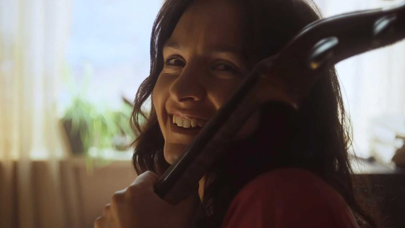 Hazel Monaghan’s Young Carol smiling and playing the Cello in Black Mirror’s “Eulogy”