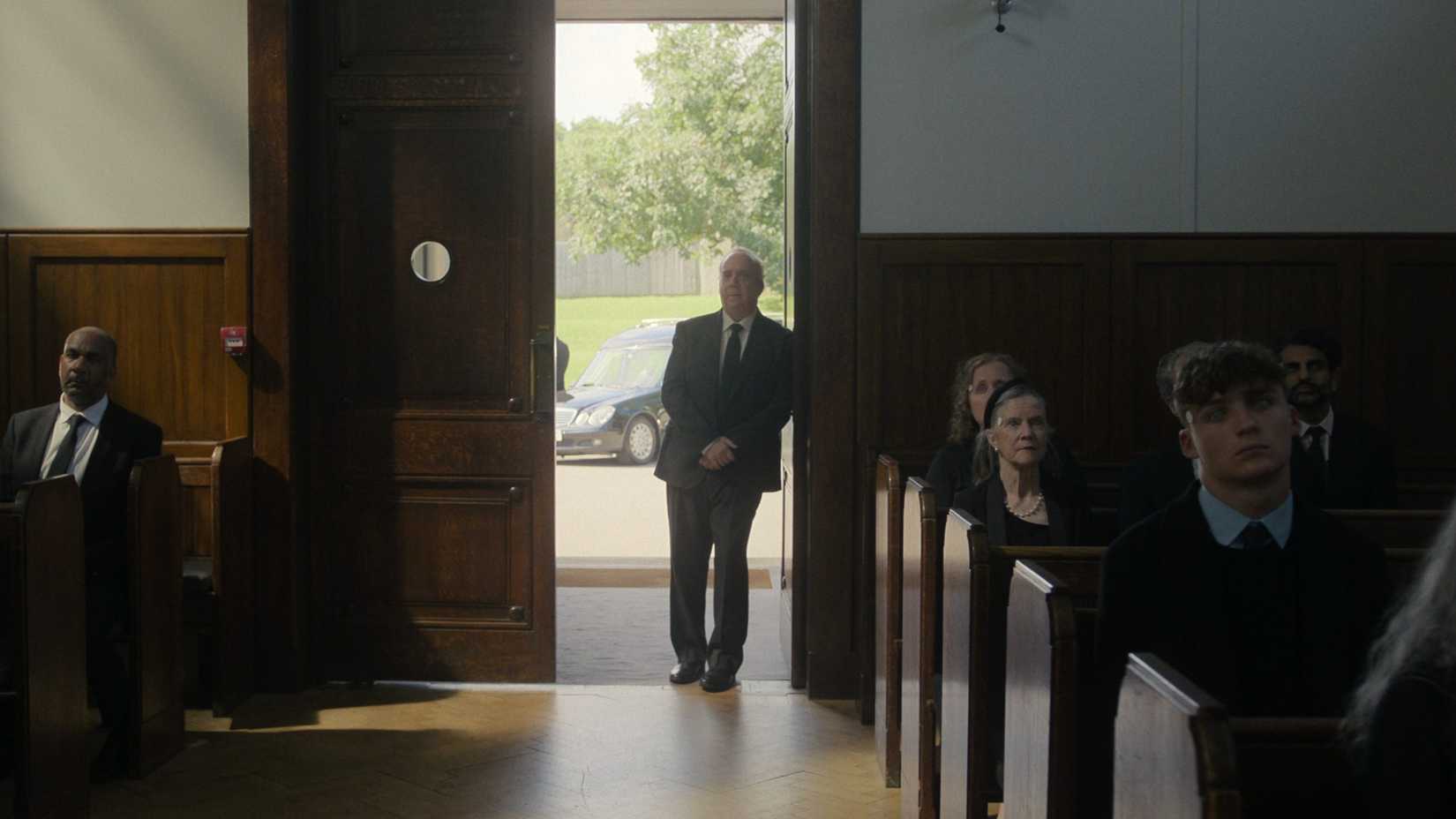 Paul Giamatti’s Philip standing at the entrance of a church in Black Mirror’s “Eulogy”