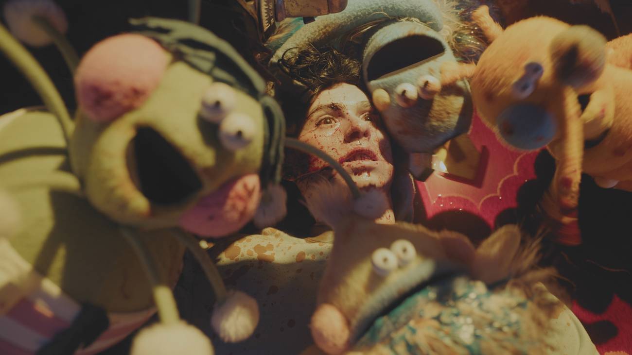 A bloody person surrounded by whimsical puppets in VHS Mixtape