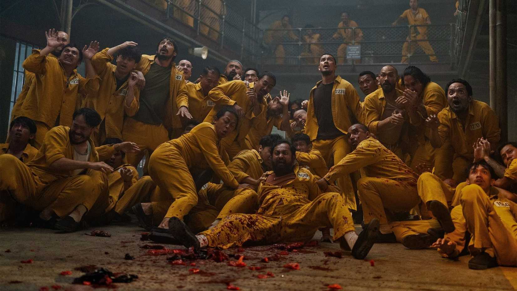 A group of prisoners looking scared and covered in blood in Ghost in the Cell (2026)