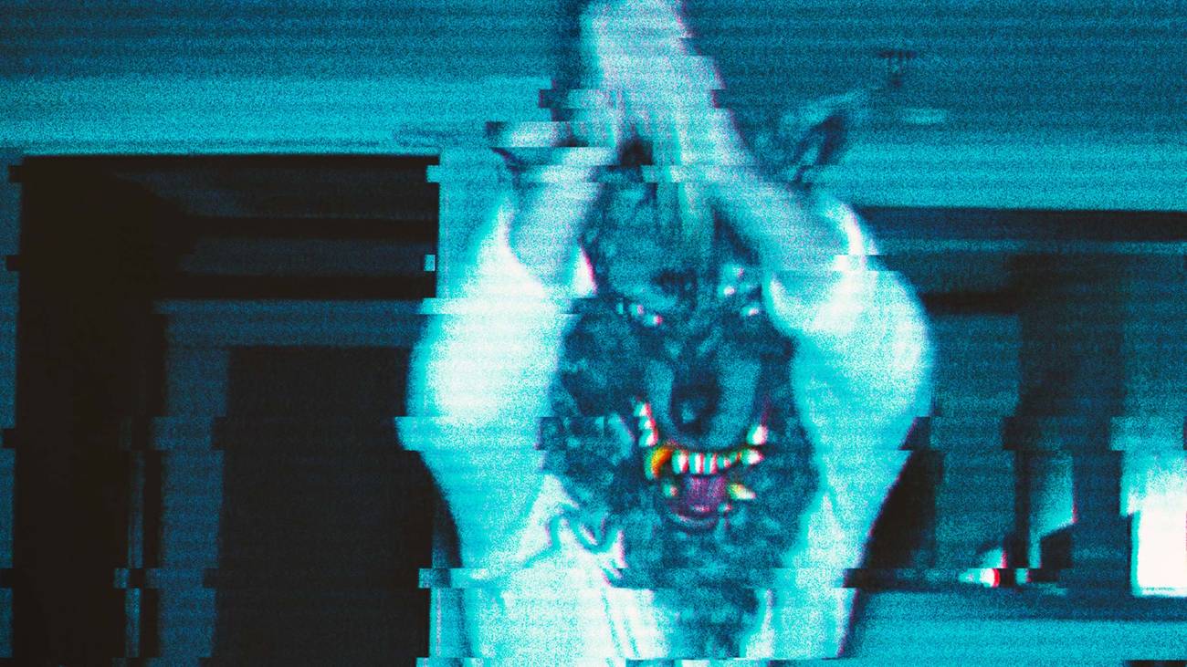 A person wearing a werewolf mask is holding a knife in The Creep Tapes