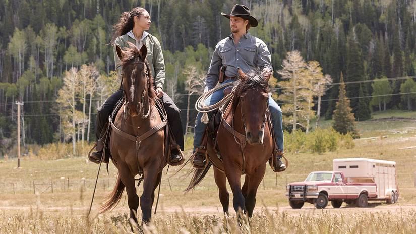 Ash Santos' Andrea and Luke Grimes' Kayce riding horses next to each other in Marshals season 2