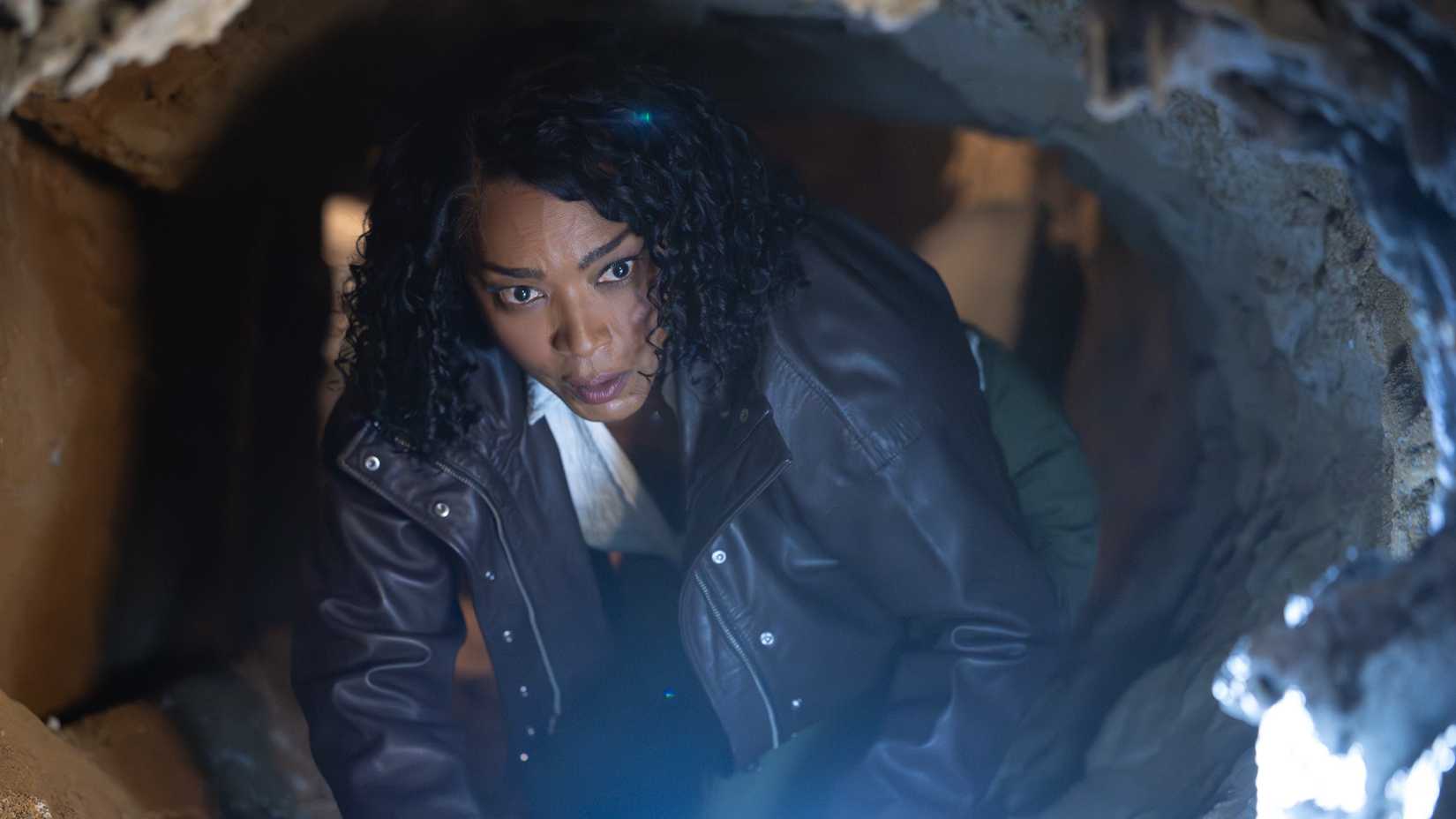 Angela Bassett crawling through a tunnel as Athena in 9-1-1 season 10, episode 1.