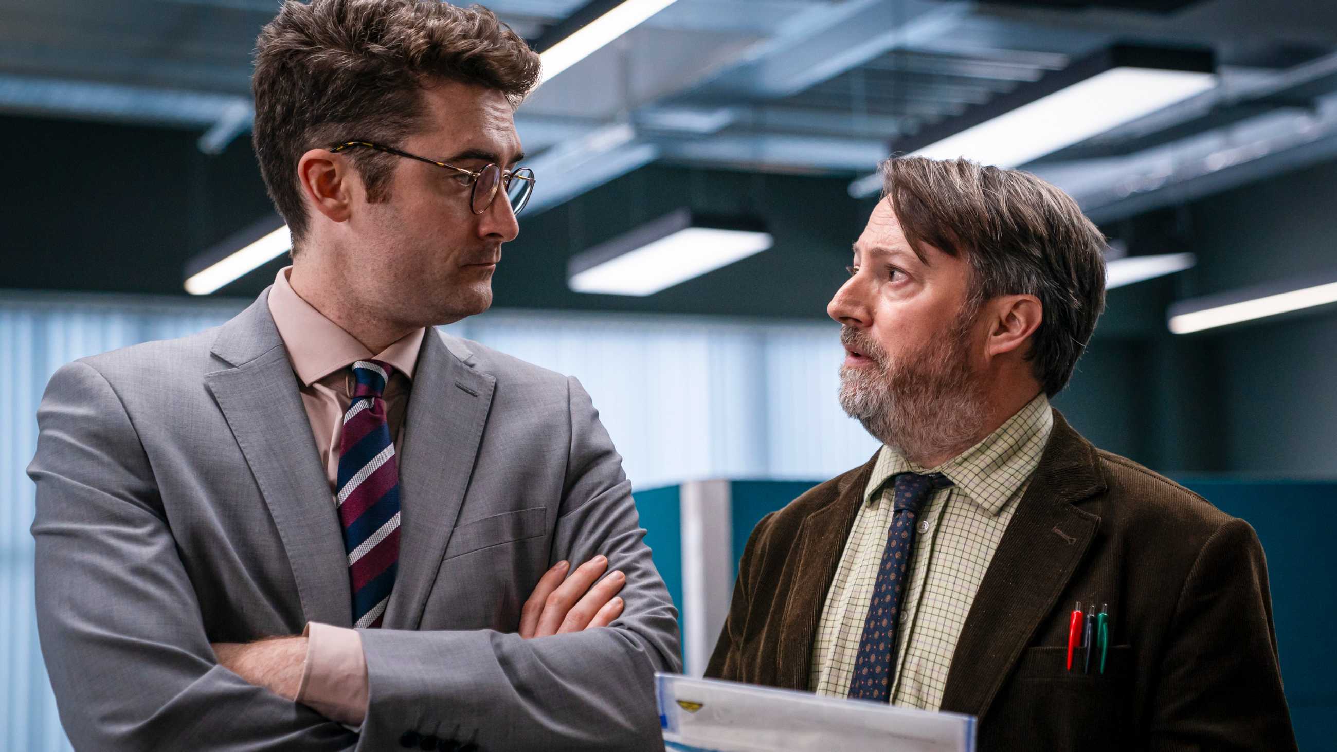 Ben Ashenden as DC Cole and David Mitchell as John "Ludwig" Taylor looking at each other in Ludwig season 2