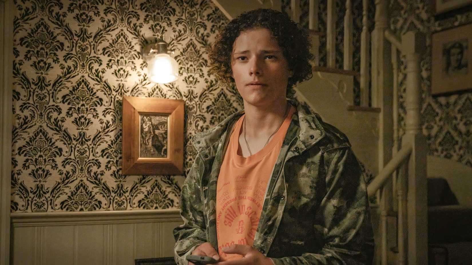 Ben stands in front of a staircase in Inside Man