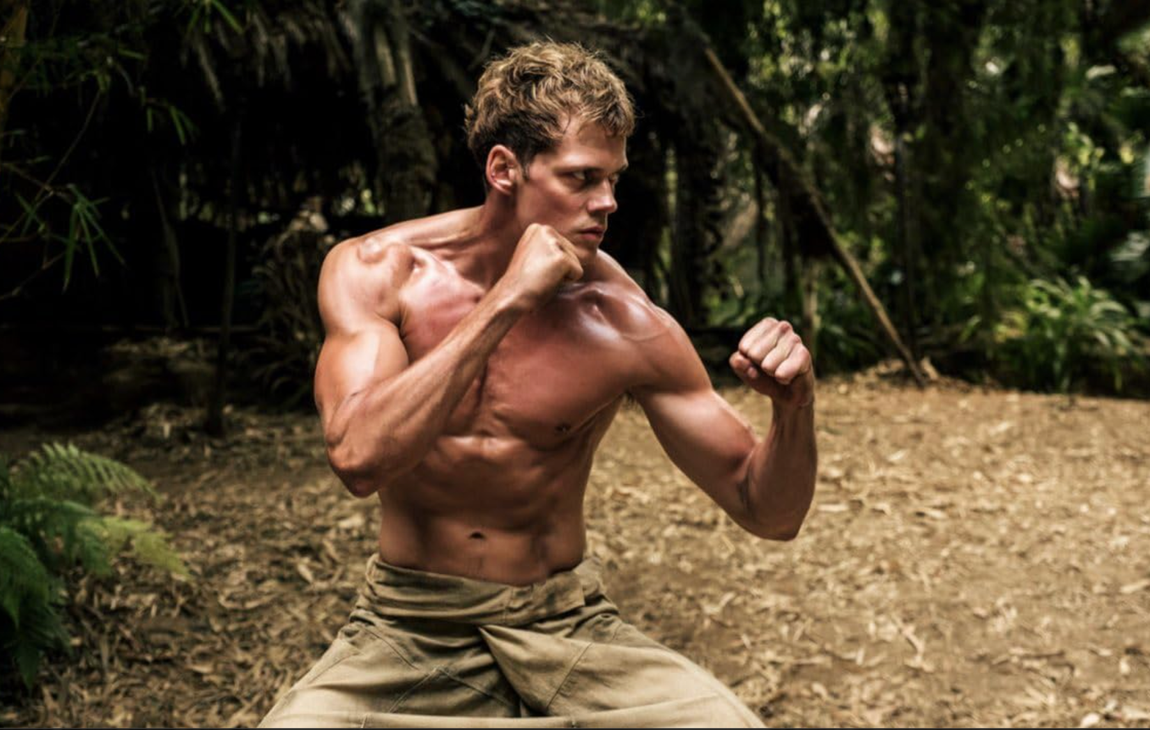 A shirtless Bill Skarsgard practices fighting in a jungle in Boy Kills World