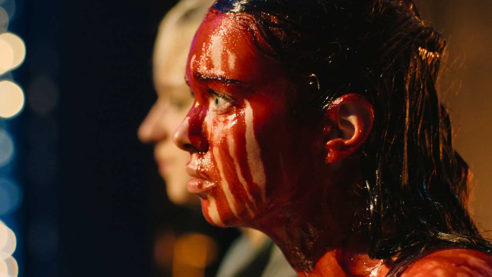 Carrie is covered in blood at the prom and Emaline stands next to her in Prime Video's Carrie