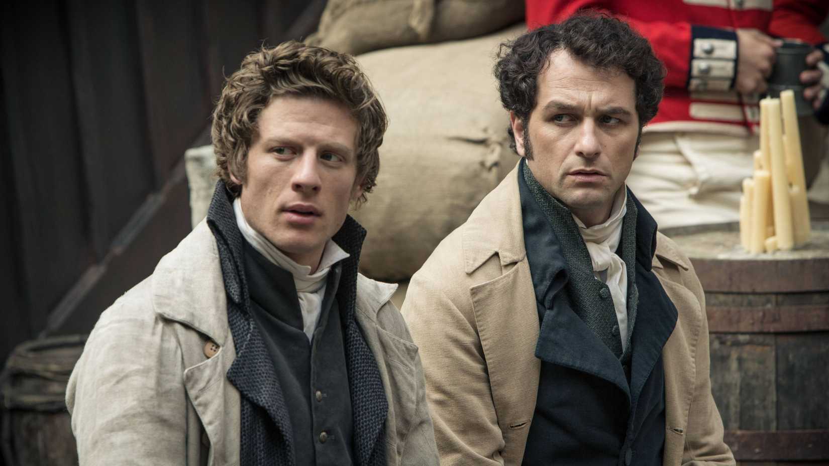 Two men in Regency attire look askance in Death Comes to Pemberley.