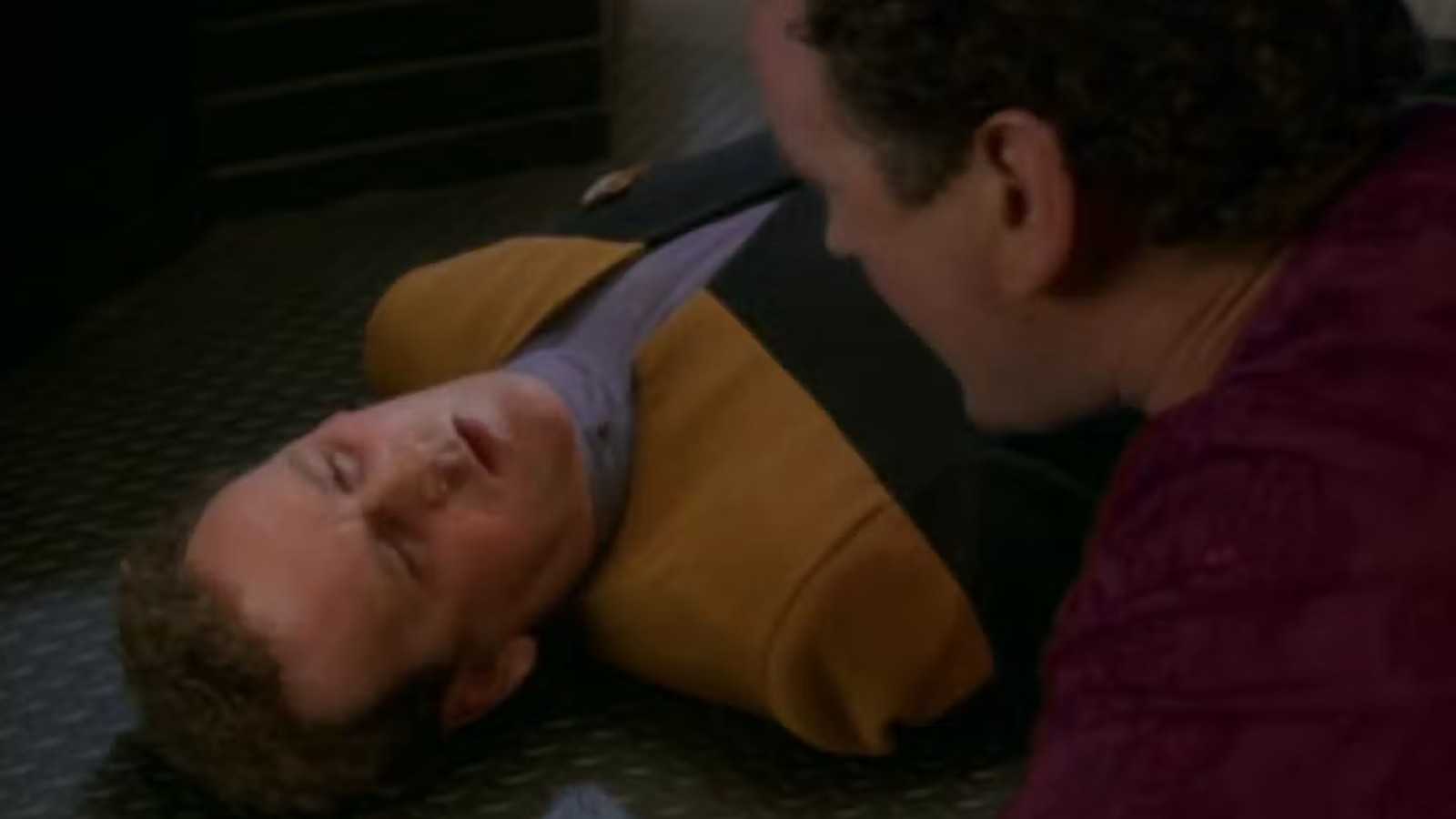Miles O'Brien stands over his own dying body