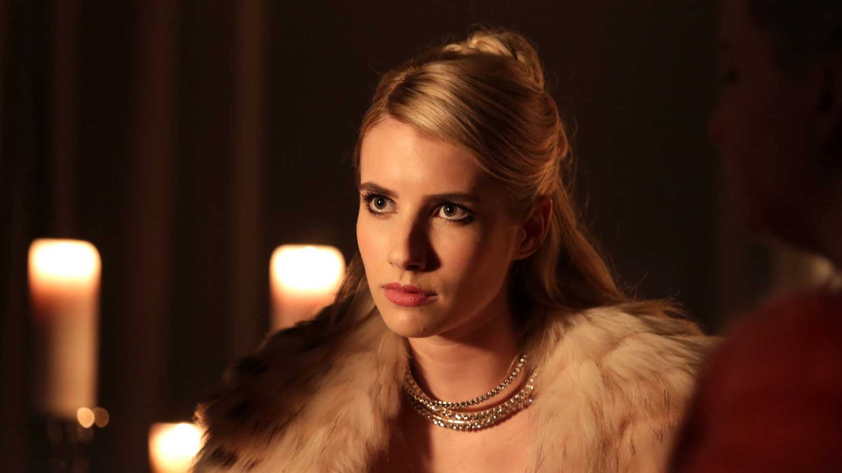Emma Roberts is in a dark room with candles in Scream Queens