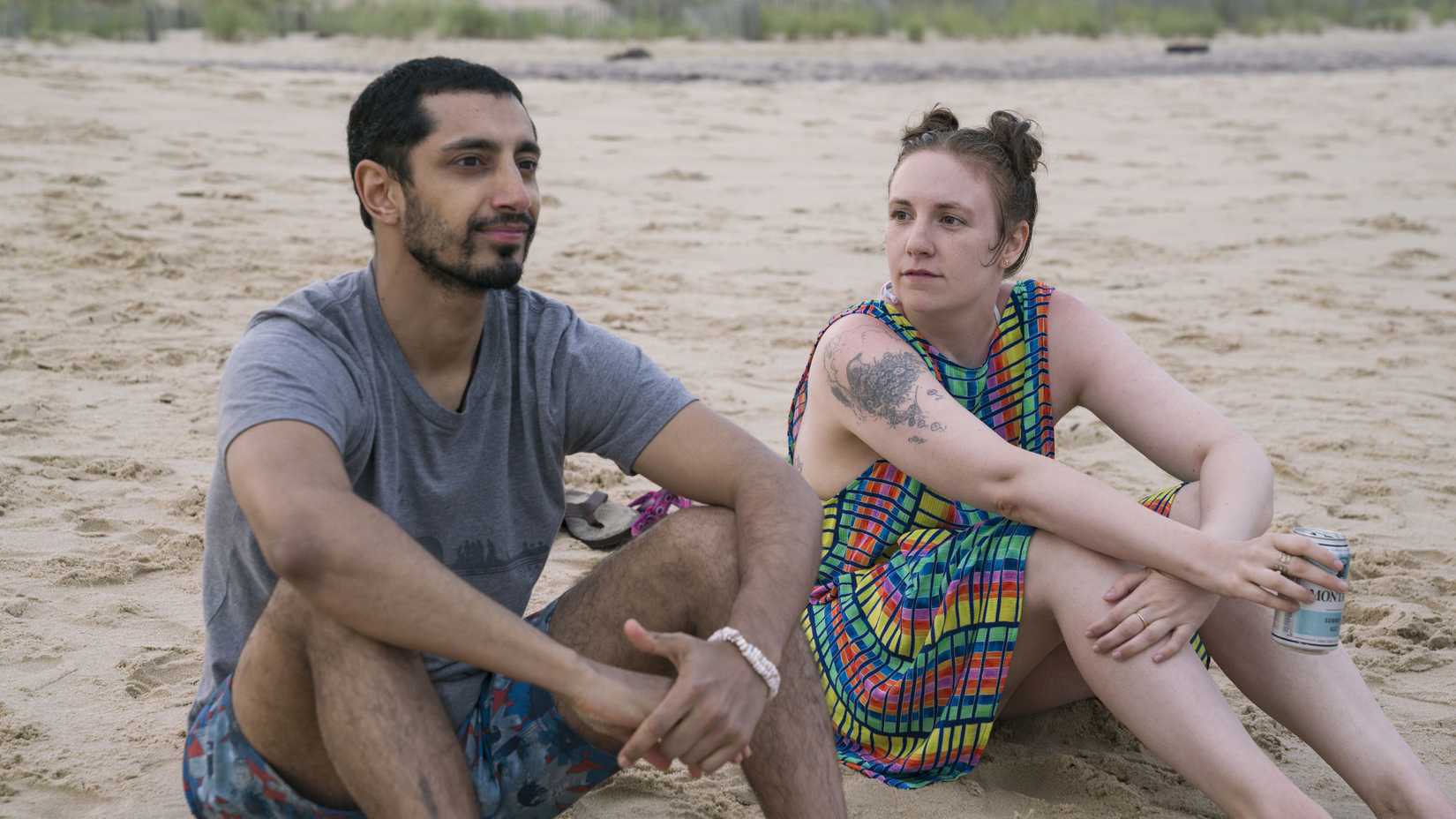 Paul-Louis (Riz Ahmed) and Hannah (Lena Dunham) sitting on the beach in Girls.