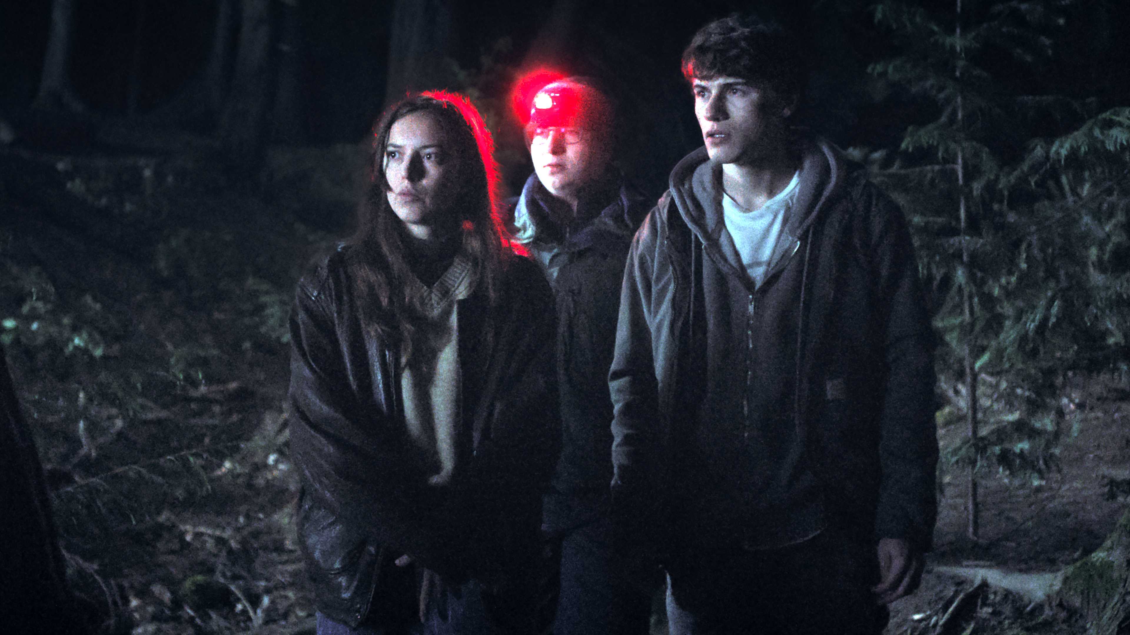 grace-brennan-s-mallory-colter-lee-s-weldon-and-sam-nivola-s-sonny-looking-suspiciously-while-standing-in-a-forest-at-night-in-phony Phony: Hulu’s New Mystery Series Is An Instantly Gripping & Enjoyable Ride | Review