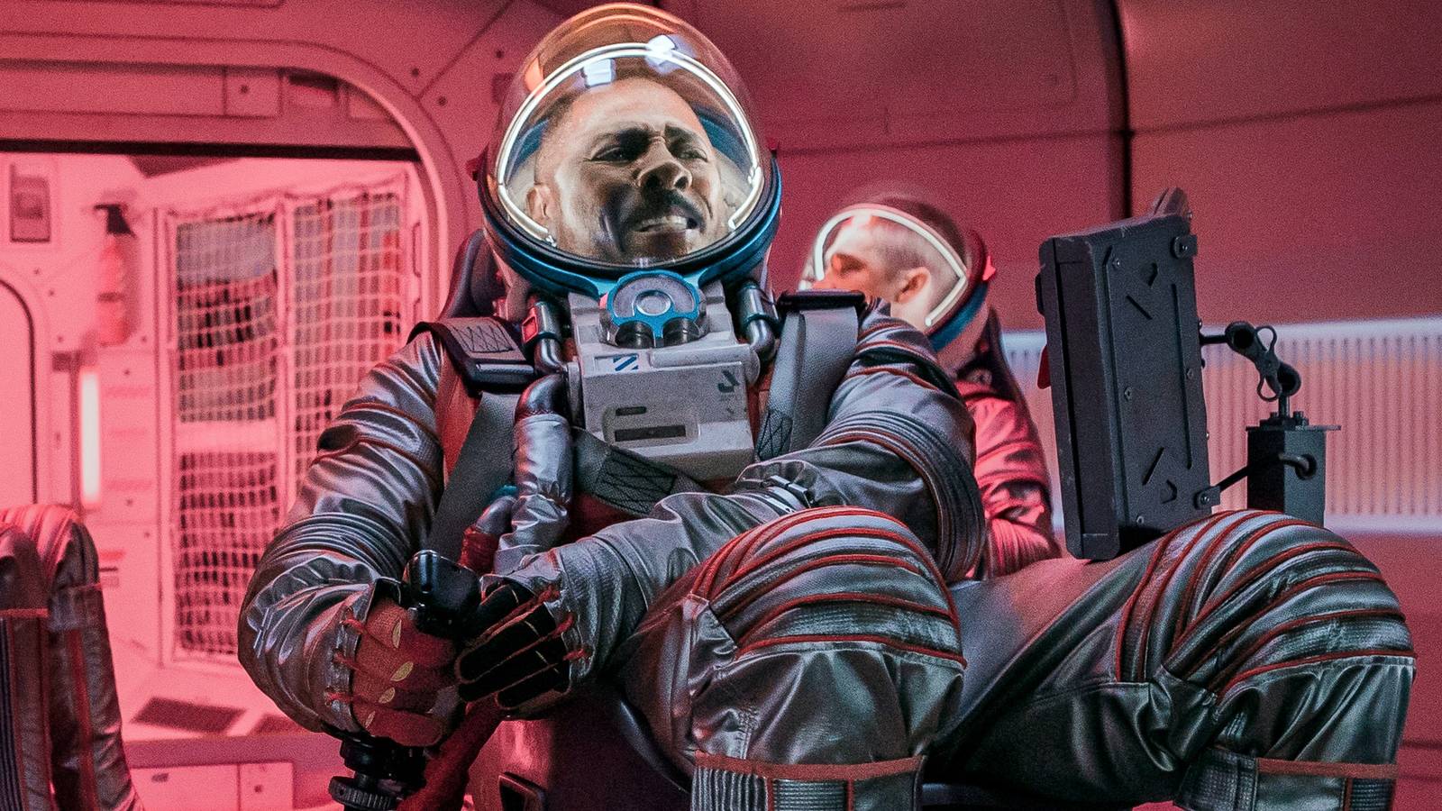 Idris Elba holding onto his seat tightly in Above the Below
