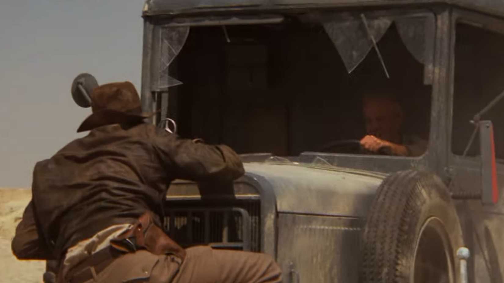 Indy holding on to the front of a truck in Raiders of the Lost Ark