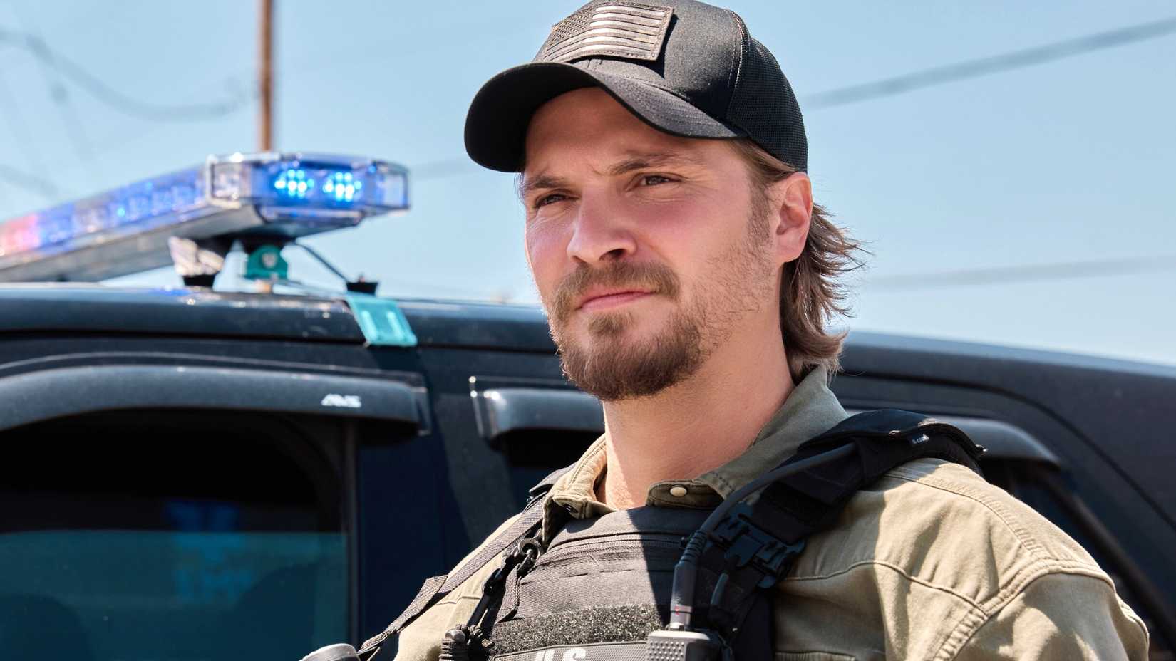 Kayce Dutton in front of a police car in Marshals season 2
