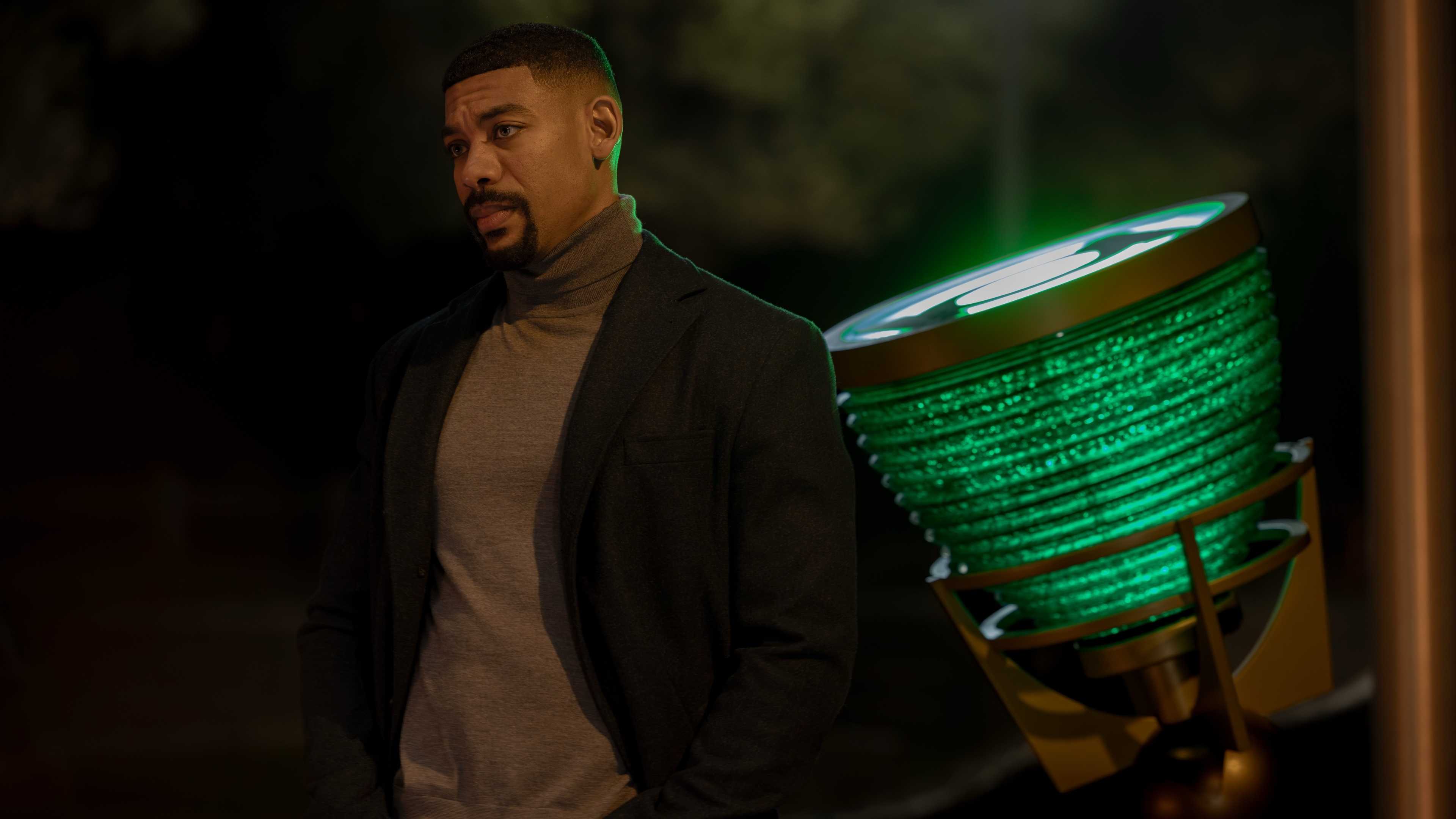 Aaron Pierre as John Stewart standing in front of the Green Lantern spotlight in Lanterns episode 6