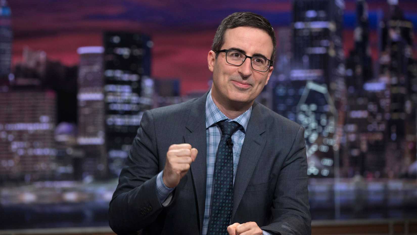 LAST WEEK TONIGHT WITH JOHN OLIVER, host John Oliver with his fist in the air, (Season 2, aired Feb. 8, 2015).